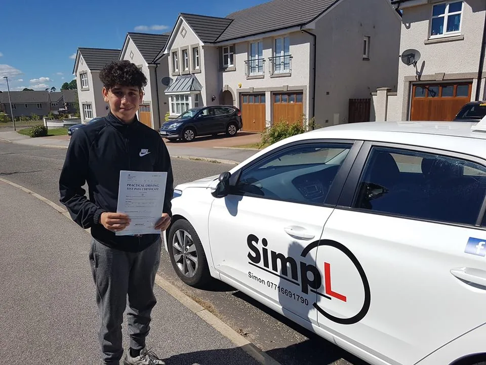 A successful SimpL learner beside the driving school car