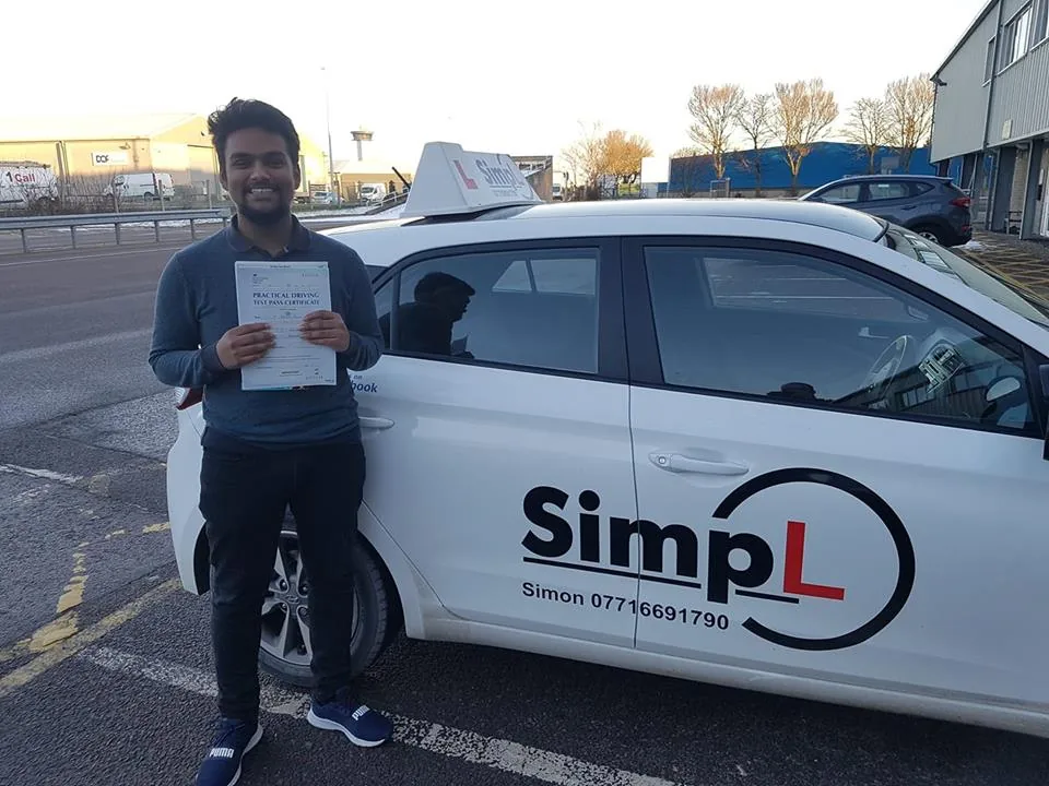 A successful learner with their pass certificate next to the SimpL Driving School car